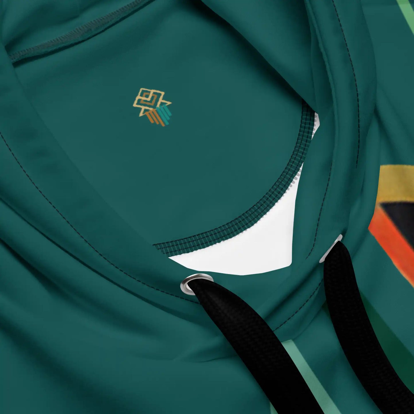 Close-up view of the teal and beige hoodie fabric and print quality. Shows texture of the material and detail of the stylized figure and abstract floral artwork printed on the fabric.