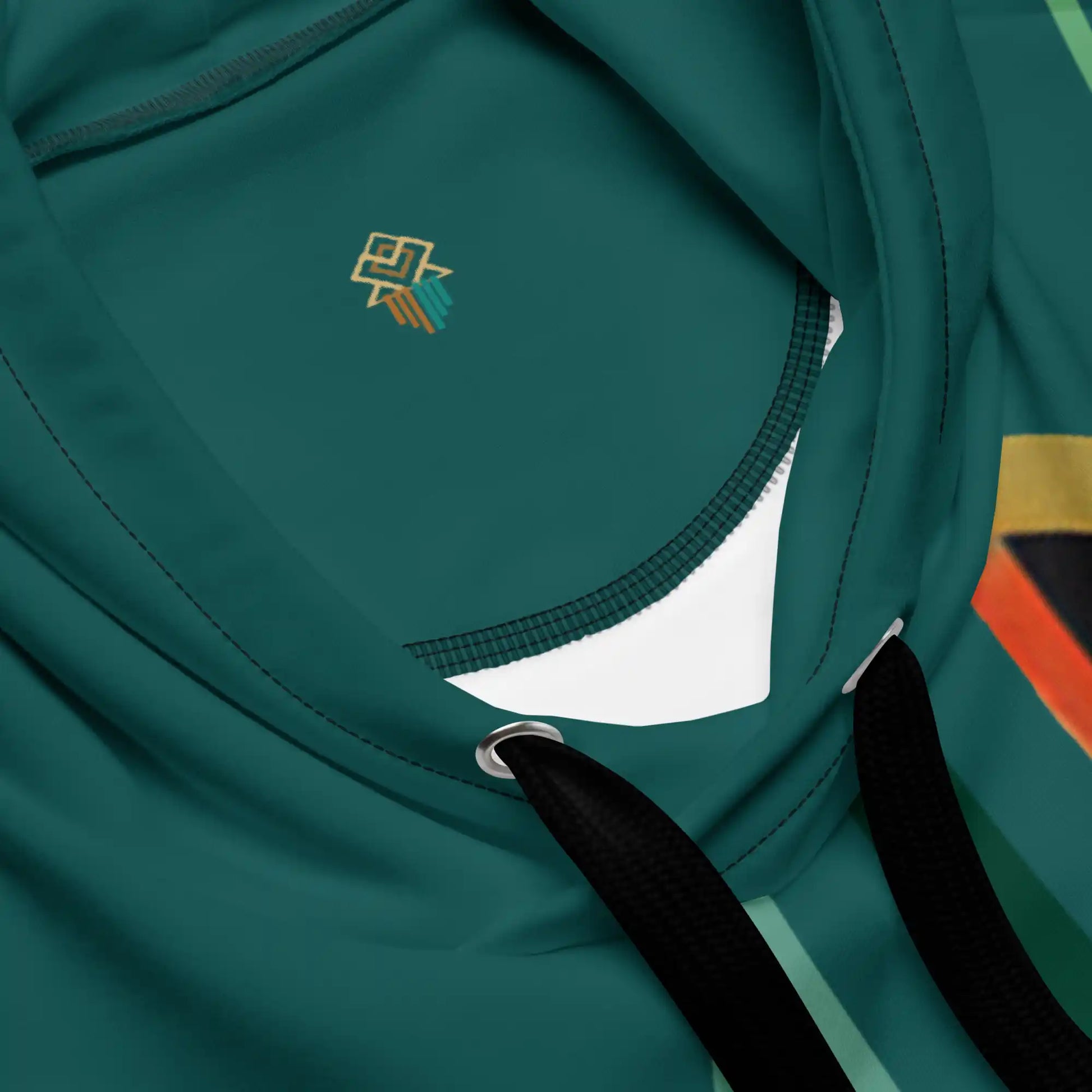 Close-up view of the teal and beige hoodie fabric and print quality. Shows texture of the material and detail of the stylized figure and abstract floral artwork printed on the fabric.