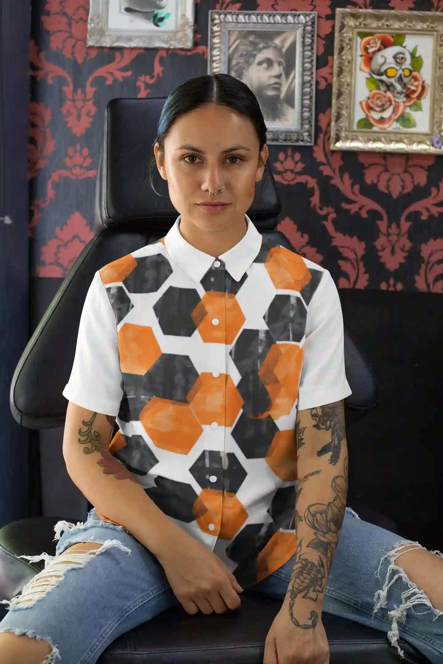 Person wearing a patterned shirt sitting in a chair with decorative wall art in the background