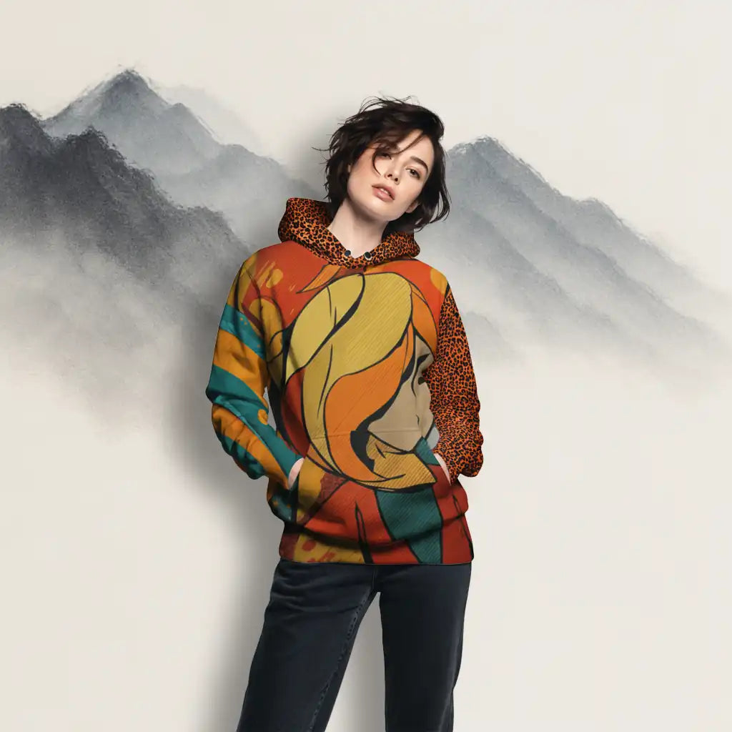 Model wearing artistic hoodie in studio with mountain background, showcasing bold street-art design.