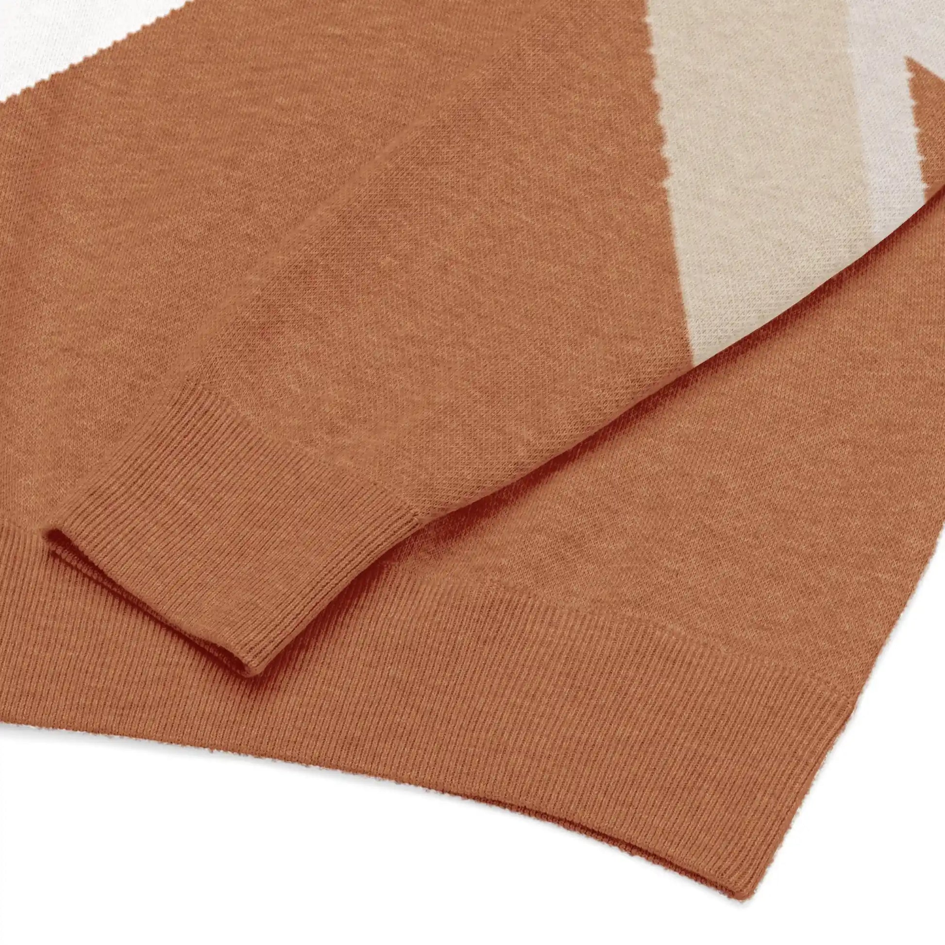 Close-up detail of the Desert Geometry knitted jacquard sweater, highlighting textured 4-color knit and warm earth-tone geometric pattern.