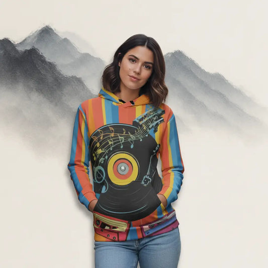 Young woman with dark hair wearing the retro music themed hoodie and jeans, standing with hands in pockets against a stylized mountain background in a studio setting.