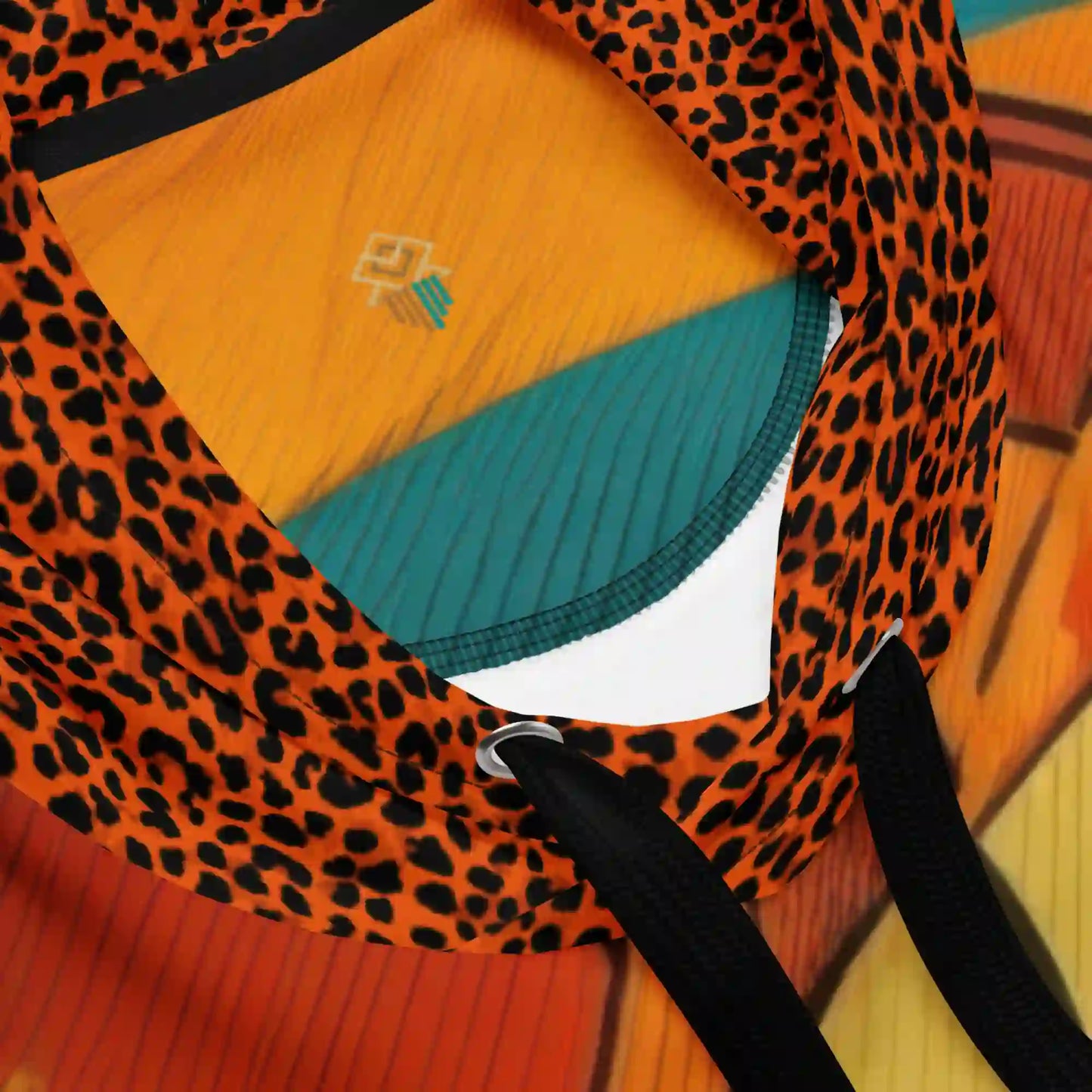 Close-up detail of hoodie drawstrings and leopard-print hood with vibrant orange and teal interior fabric.