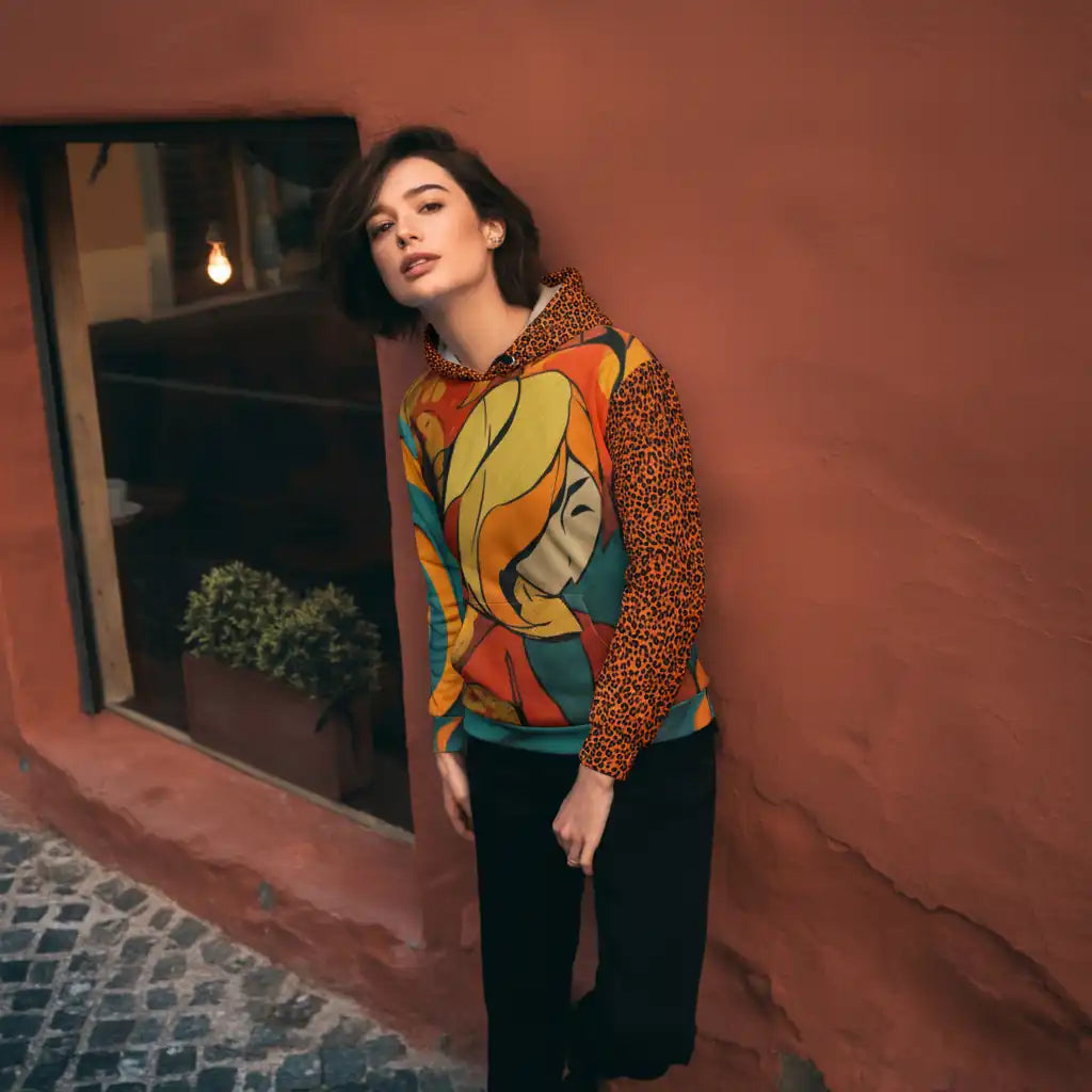 Model wearing graphic hoodie against a terracotta urban wall, highlighting pop-art design with leopard sleeves.